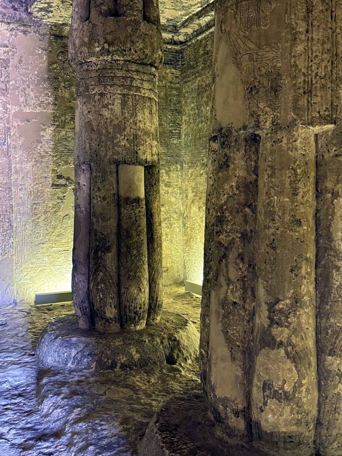 Lamplit papyrus columns inside a rock-cut tomb at Amarna