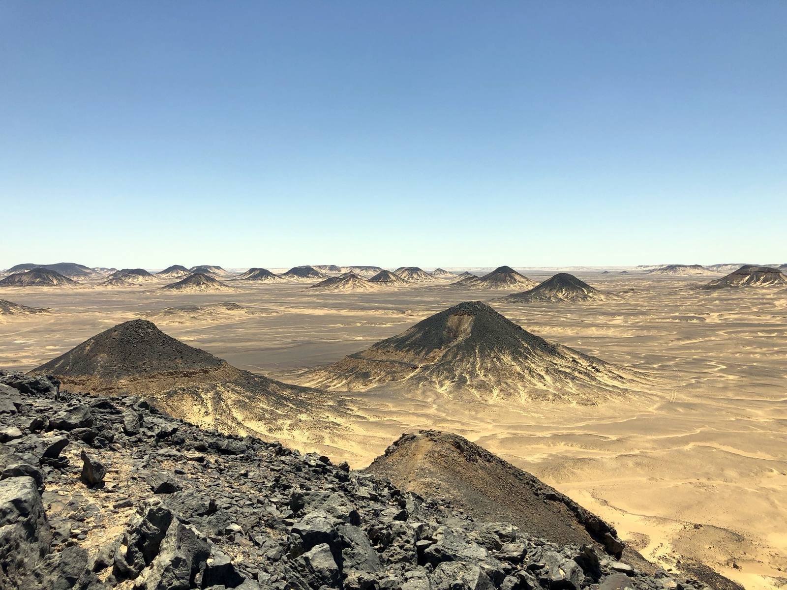 Dark volcanic-capped hills scattered across the Black Desert
