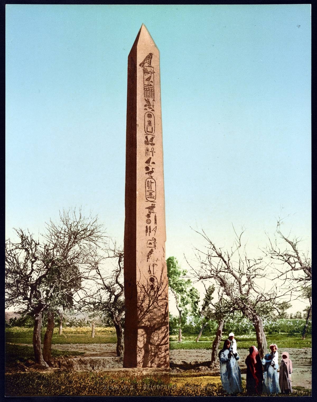 A colour photochrom of the Heliopolis obelisk among fields, c. 1890s