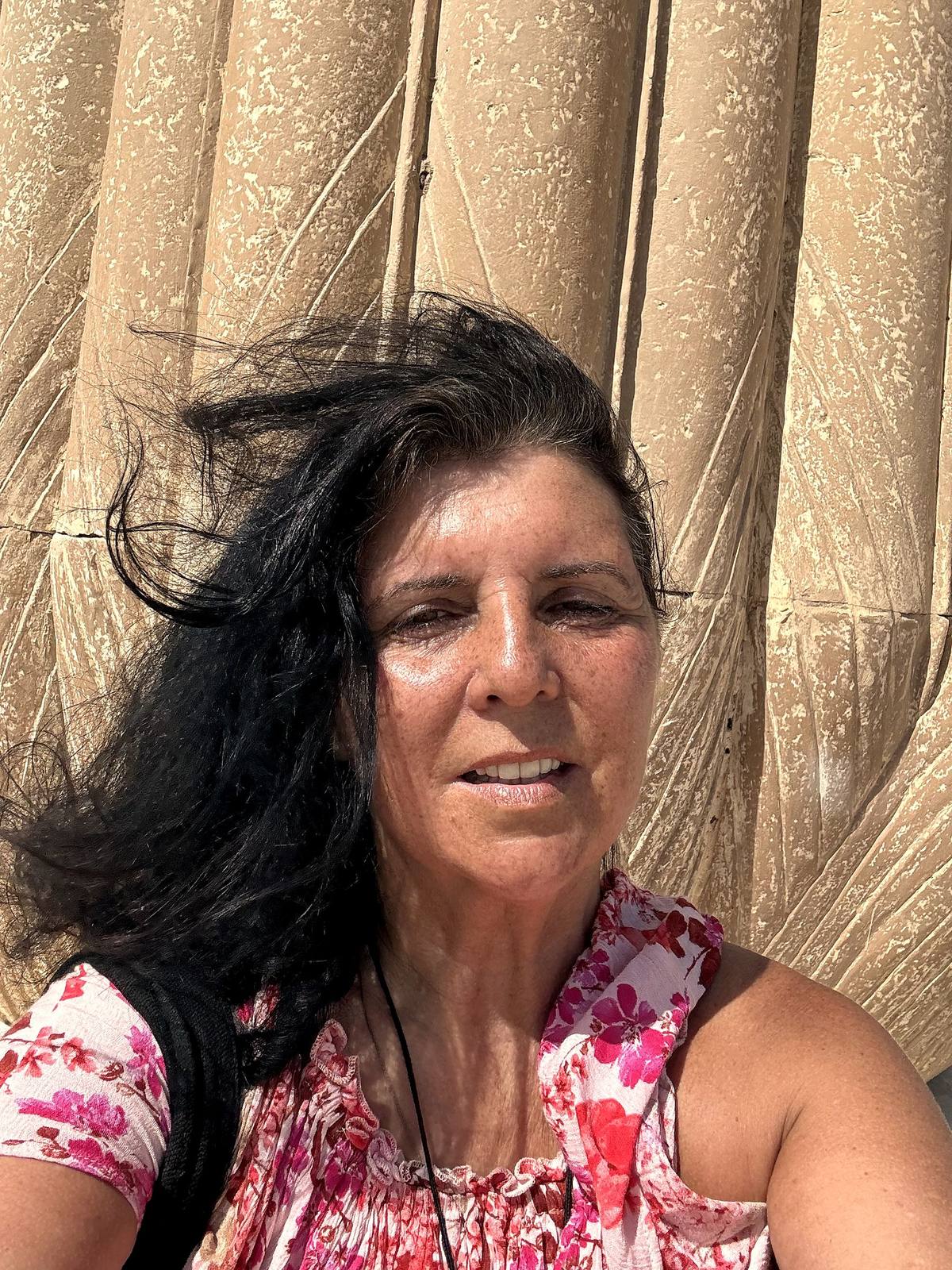 Kristina Mills beside ancient papyrus-bundle columns in Egypt