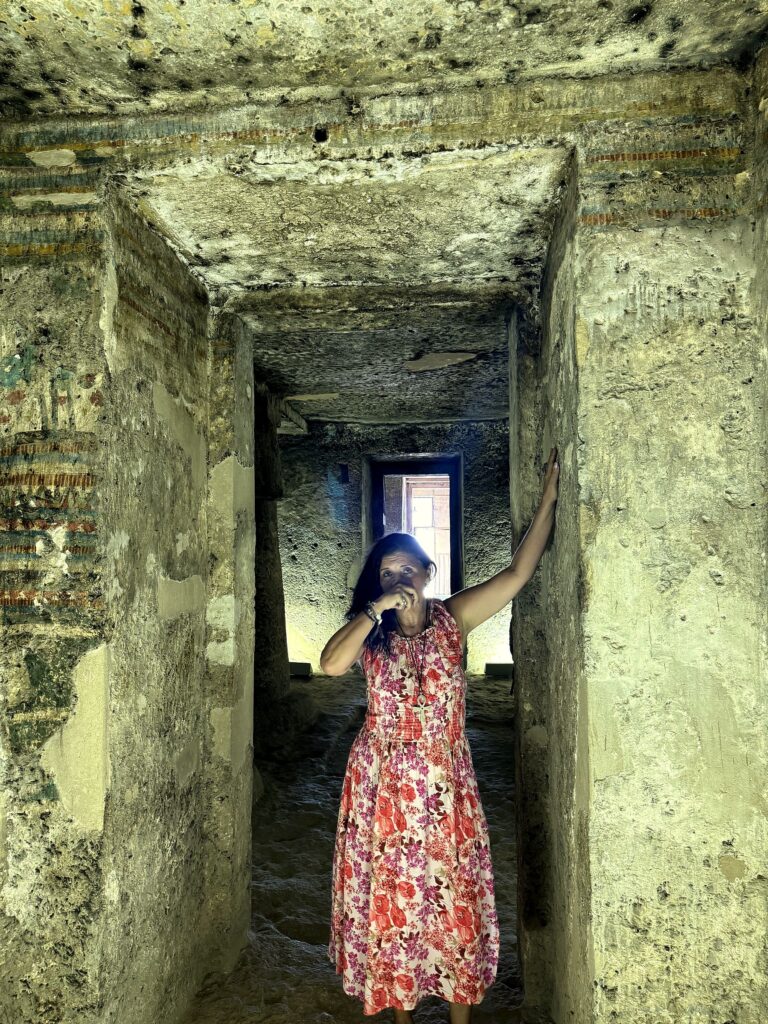 Kristina Mills in the stone corridor of an Amarna tomb