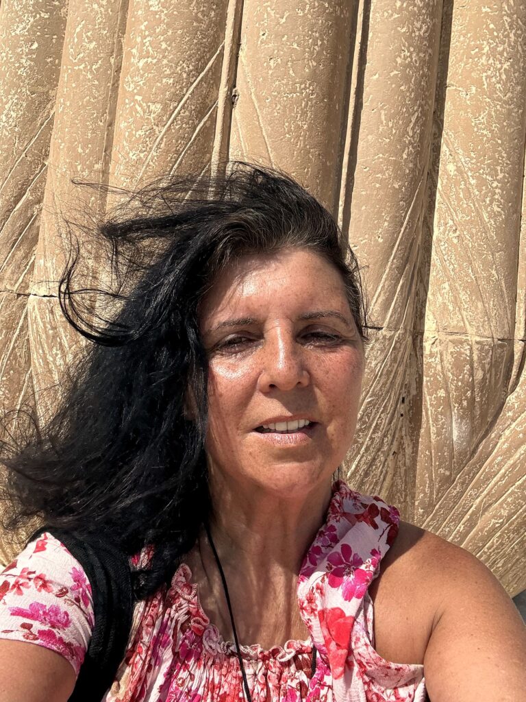 Kristina Mills beside ancient papyrus-bundle columns in Egypt